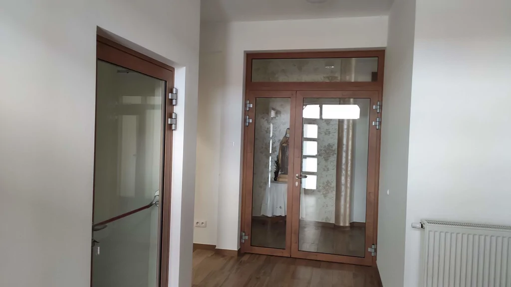 widok na korytarz, drewniane przeszklone drzwi 