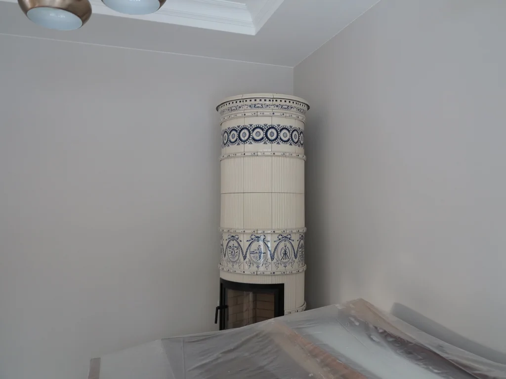 sufit podwieszany z oświetleniem led, bardzo jasny zdobiony żyrandol, widać w tle zabudowę prysznica 