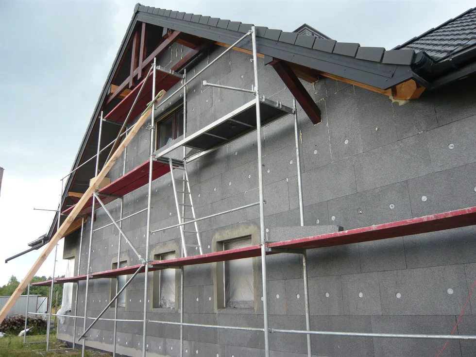 Ocieplenie elewacji styropianem na rusztowaniu, przygotowanie pod warstwę zbrojoną i tynk