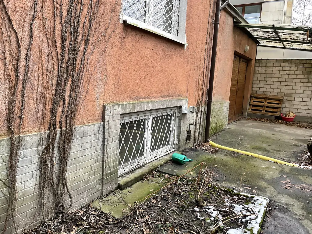 Stan budynku przed remontem – przyziemie i boczna elewacja z widocznymi śladami zużycia.