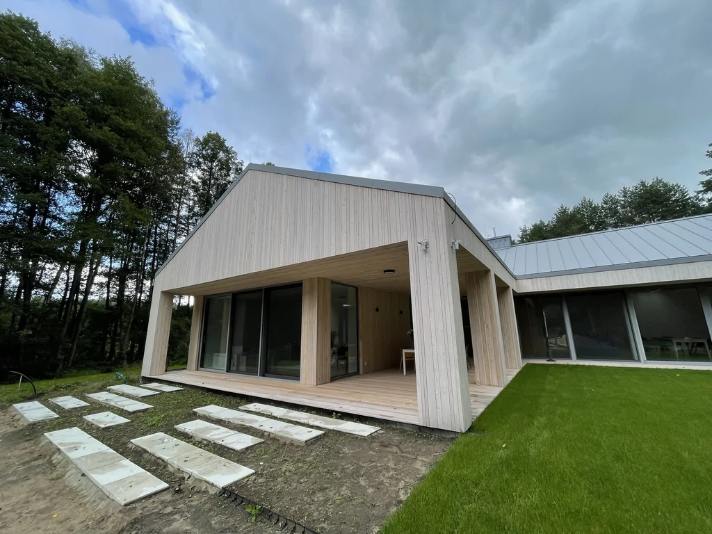 Taras drewniany z zadaszeniem przy nowoczesnym domu w lesie