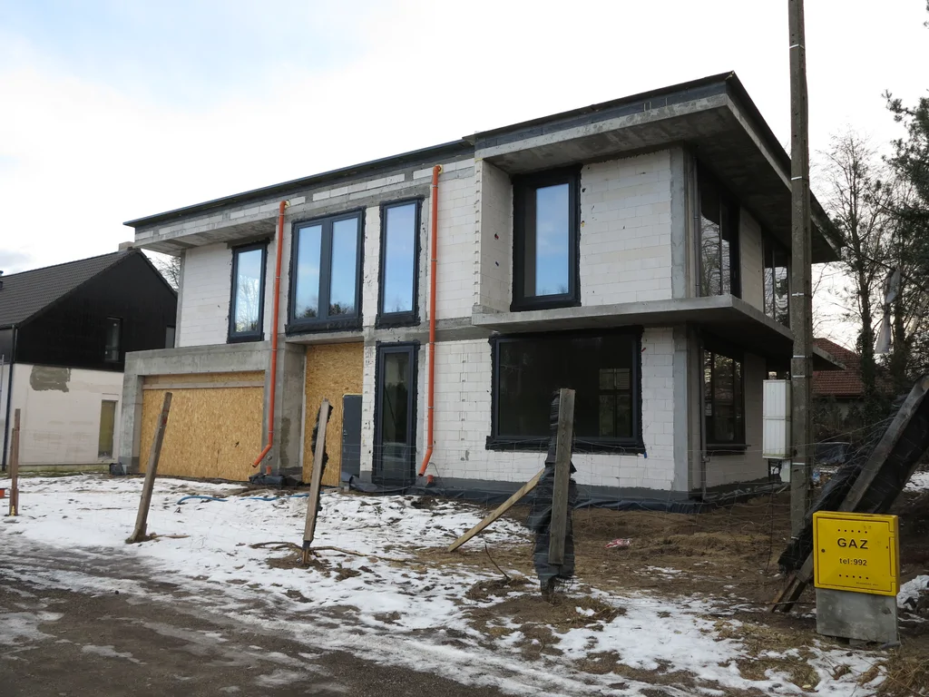 Stan surowy budynku, ściany pustak ceramiczny, dach płaski, duże przeszklenia