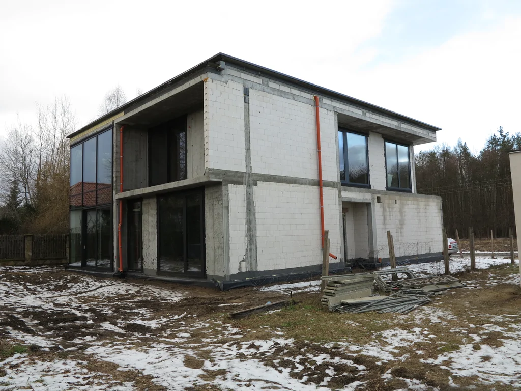 Stan surowy budynku, ściany pustak ceramiczny, dach płaski, duże przeszklenia