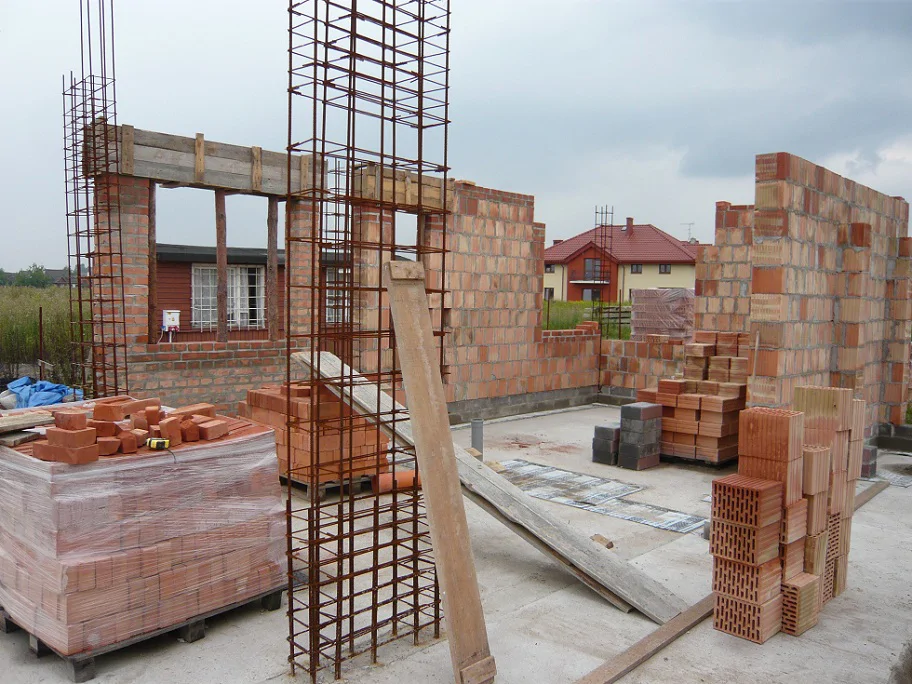 Murowanie ścian z pustaków ceramicznych, zbrojenie słupów i otwory okienne na parterze