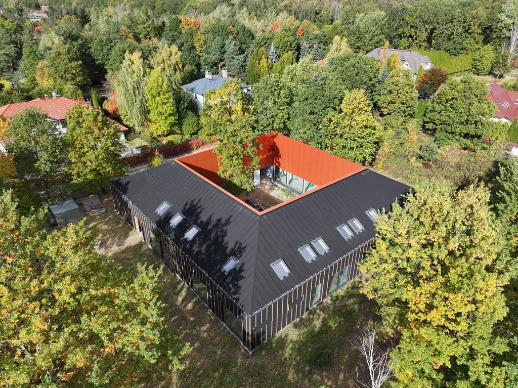 Dom z wewnętrznym ogrodem na tle zabudowy jednorodzinnej