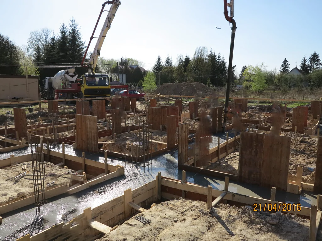 Wylewanie ław fundamentowych, w tle pompa do betonu 