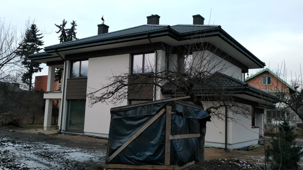 Dom jednorodzinny z dużymi przeszkleniami i dachem kopertowym