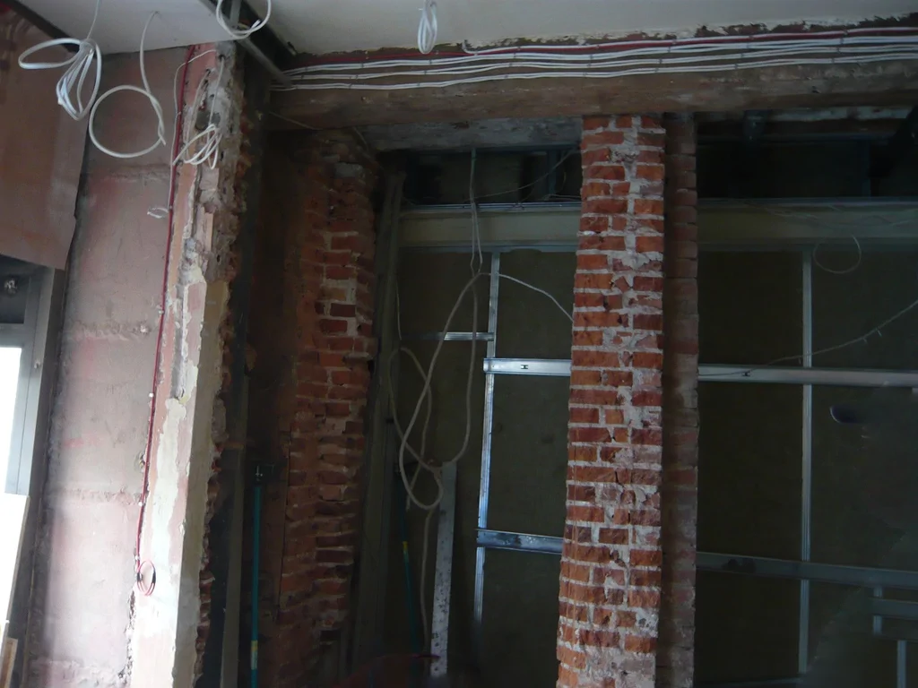 Prace instalacyjne w Green Caffè Nero, ceglane filary i konstrukcja z profili stalowych