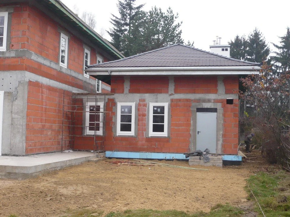 budynek garażowy/przybudówka z drzwiami i oknami, rusztowanie przy ścianie