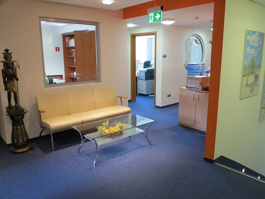 Wykonany remont biura podróży, wykładzina stolik szklany, pomalowane ściany 