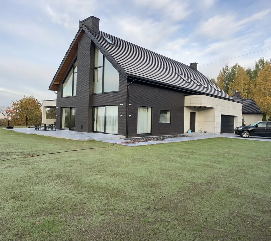 Nowoczesny dom z dużymi przeszkleniami i dachem dwuspadowym – widok narożny