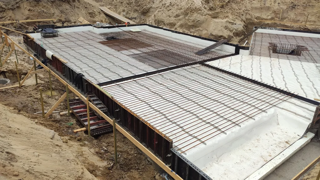 Widok zbrojenia płyty fundamentowej oraz przygotowanej konstrukcji piwnicy w technologii białej wanny