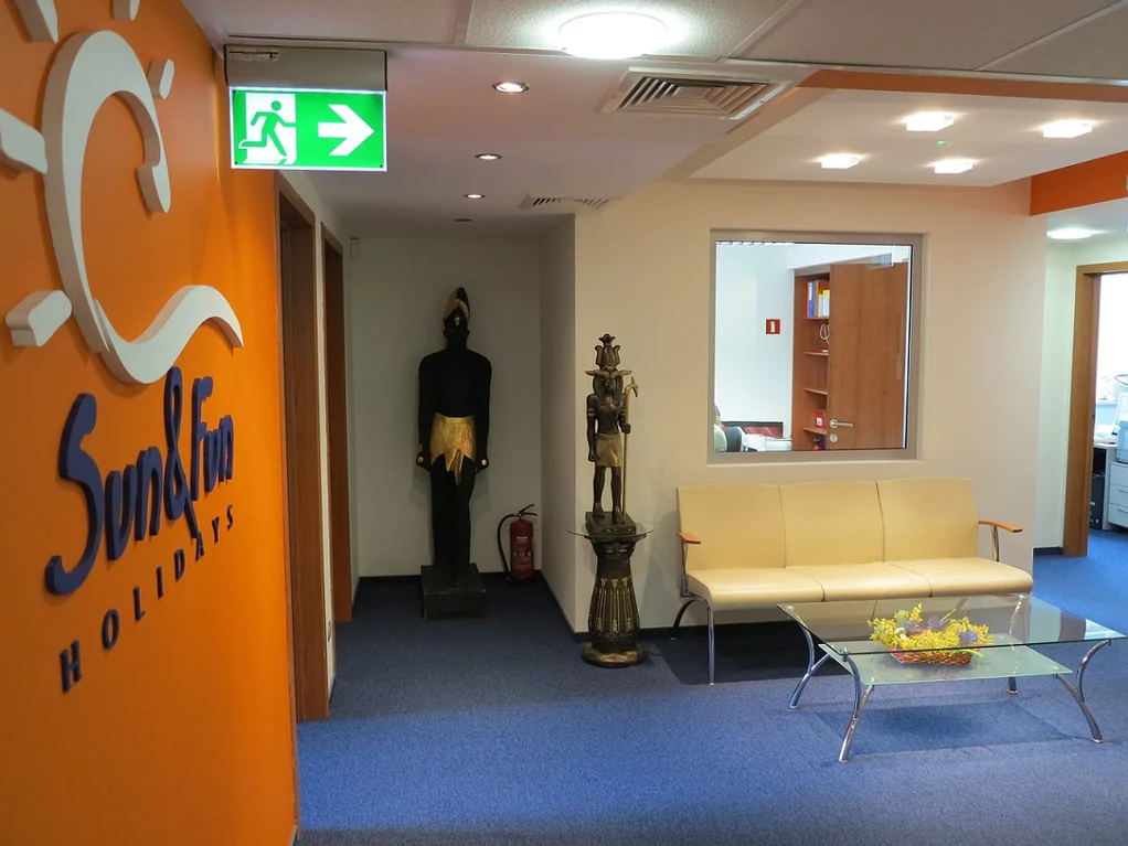 Wykonany remont biura podróży, wykładzina stolik szklany, pomalowane ściany 