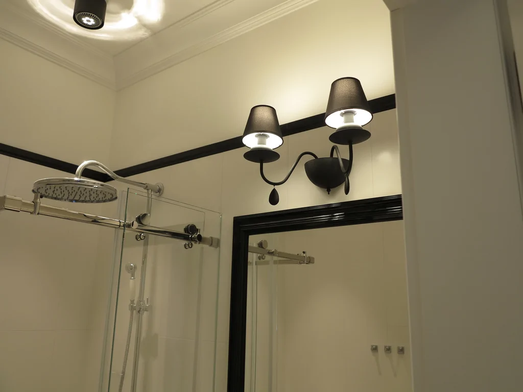 kuchnia w stylu dworkowym, z jasną stolarką okienną i meblami, w kuchni ciemny blat z kamienia 