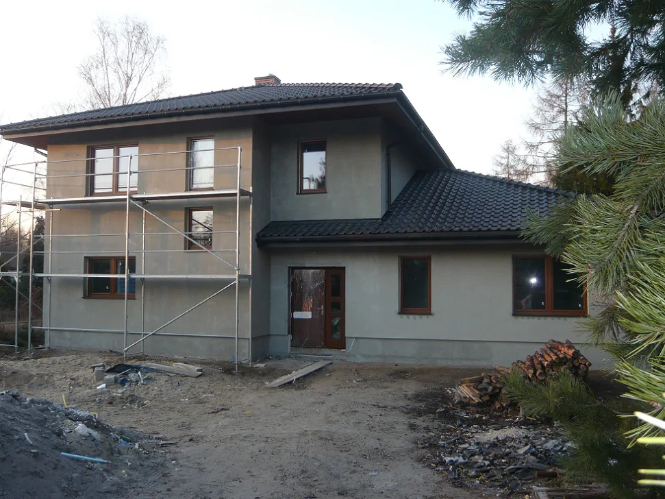 Elewacja w trakcie prac – tynk zewnętrzny, stolarka okienna i rusztowanie przy budynku