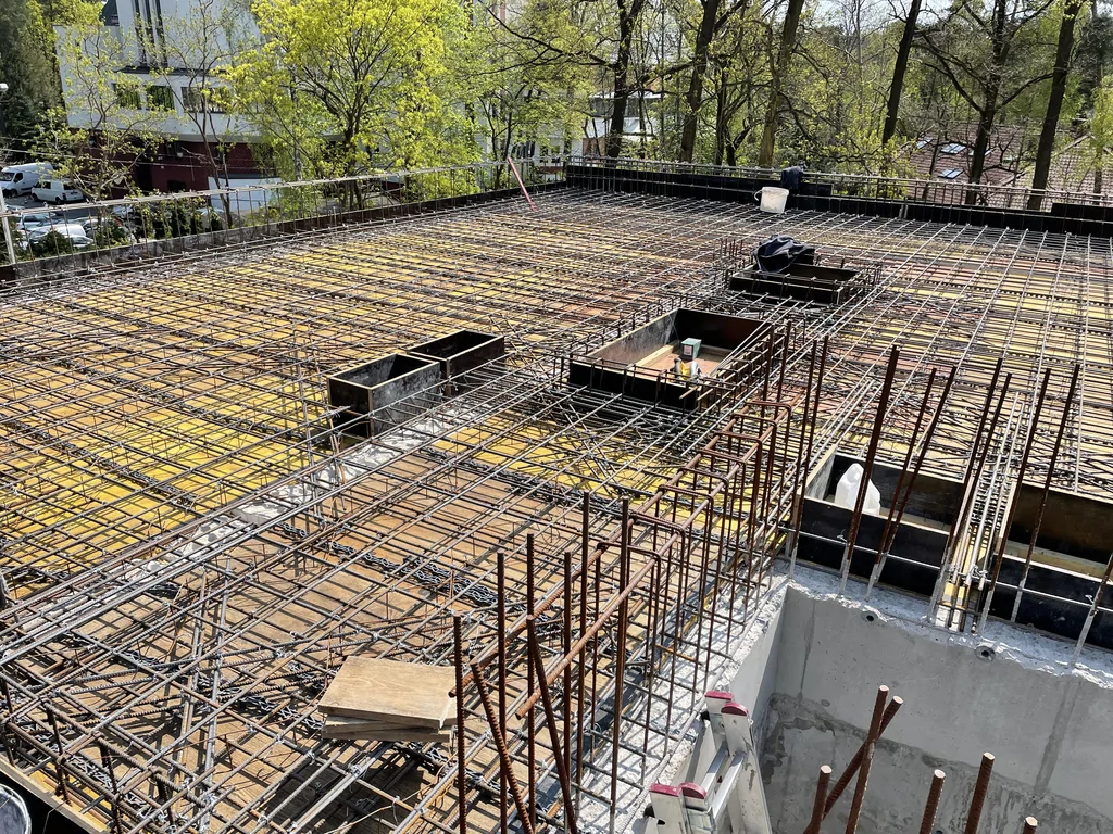 Zbrojenie stropu z otworami technologicznymi i wyprowadzonymi prętami na budowie domu w Konstancinie
