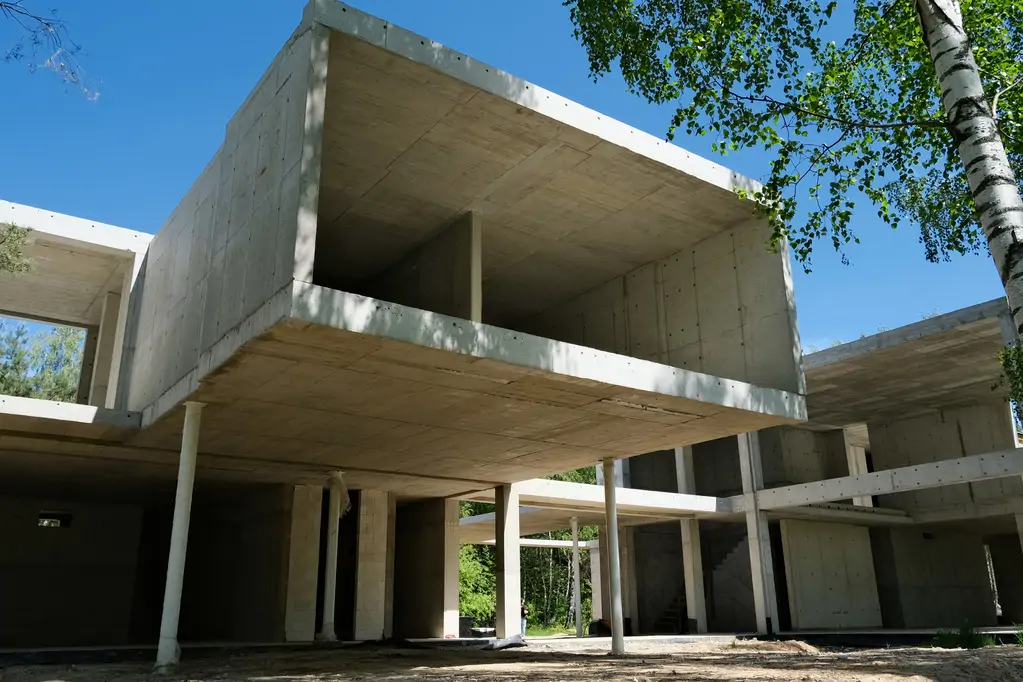 Zbliżenie żelbetowej bryły piętra z dużym nadwieszeniem w nowoczesnym domu podczas budowy.