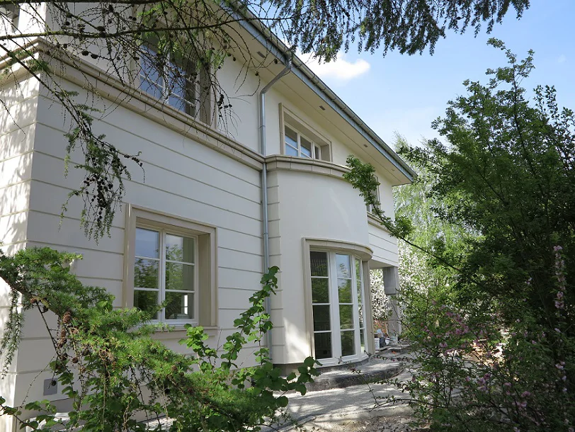 elewacja boczna domu z zaokrąglonym wykuszem i wyjściem na taras, otoczenie zieleni