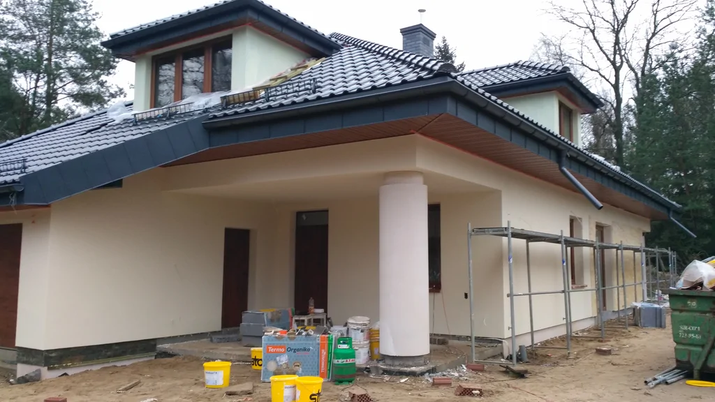 Jasna elewacja strefa wejścia, dach pokryty blachą na rabek, okrągły słup, 