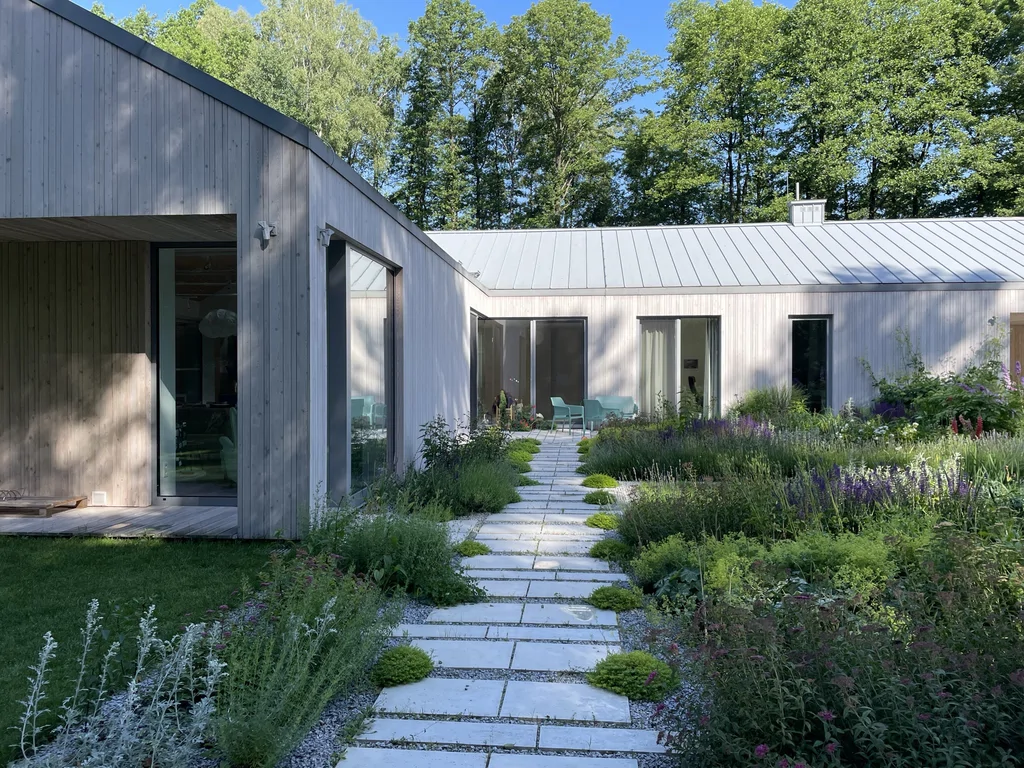 Patio i komunikacja piesza – przeszklenia strefy dziennej oraz drewniana okładzina elewacyjna