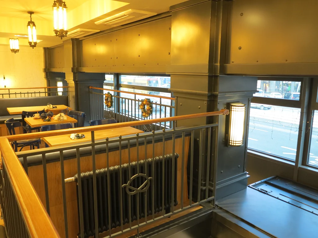 Wnętrza piekarni w stanie deweloperskim, stoliki, witryna okienna 