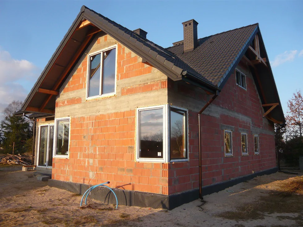 Stan surowy zamknięty: zamontowane okna i pokrycie dachowe, elewacja przed ociepleniem