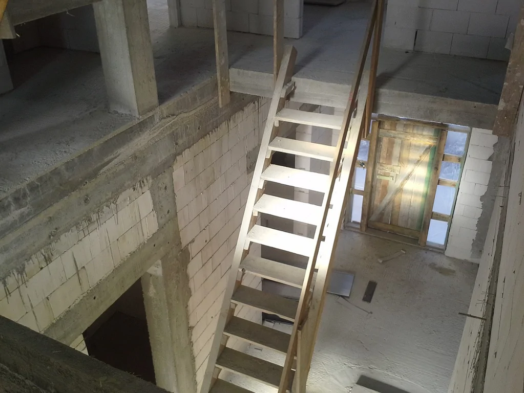 Budowa domu jednorodzinnego, zdjęcie wewnątrz widok na klatkę schodową i elementy żelbetowe konstrukcyjne