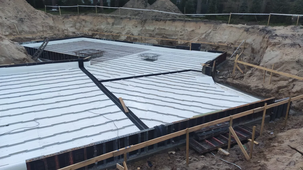 Płyta fundamentowa domu jednorodzinnego ze szczelną piwnicą w technologii białej wanny podczas przygotowania do betonowania