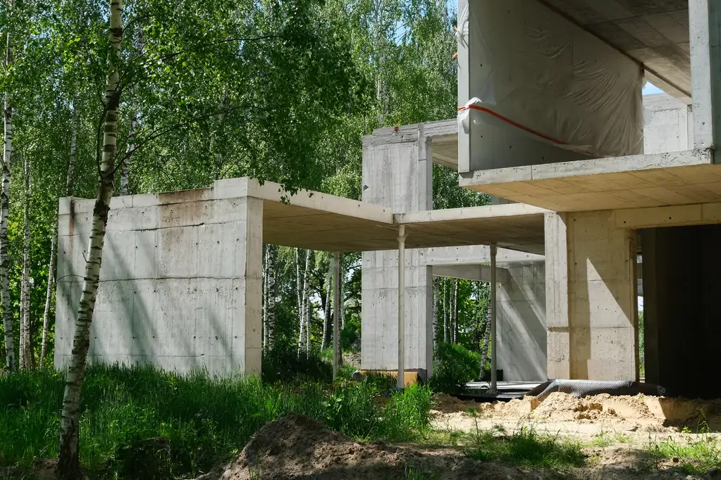 Żelbetowe zadaszenie i boczna część budynku mieszkalnego w trakcie realizacji stanu surowego.