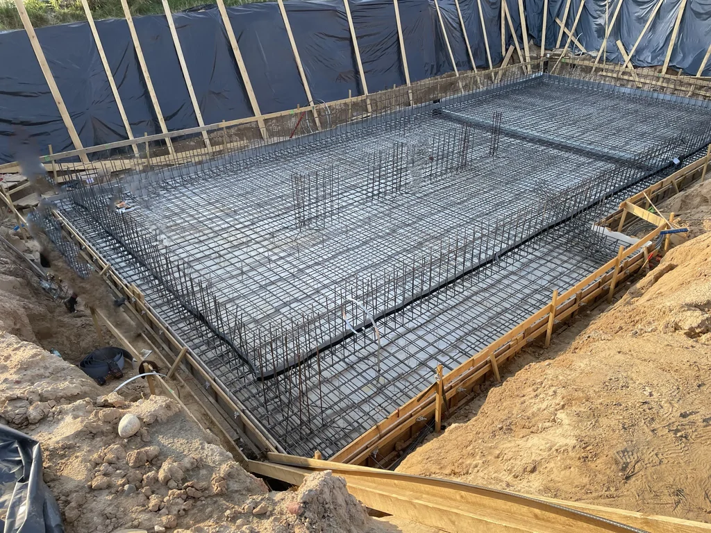 Zbrojenie i deskowanie płyty fundamentowej piwnicy na etapie przygotowania do betonowania