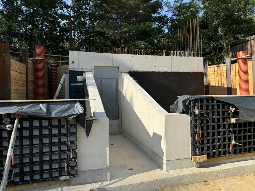 Żelbetowe zejście do części podziemnej z szalunkami systemowymi i przygotowaniem pod dalsze prace konstrukcyjne.