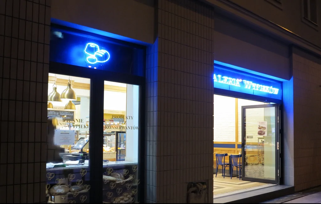 Zdjęcia z zewnątrz, podświetlane logo piekarni, stolarka okienna ciemna, wykonana elewacja 