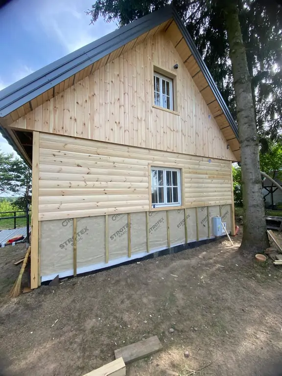 Domek drewniany w trakcie odnowienia elewacji – montaż nowego szalunku i wykończenia wokół okien.