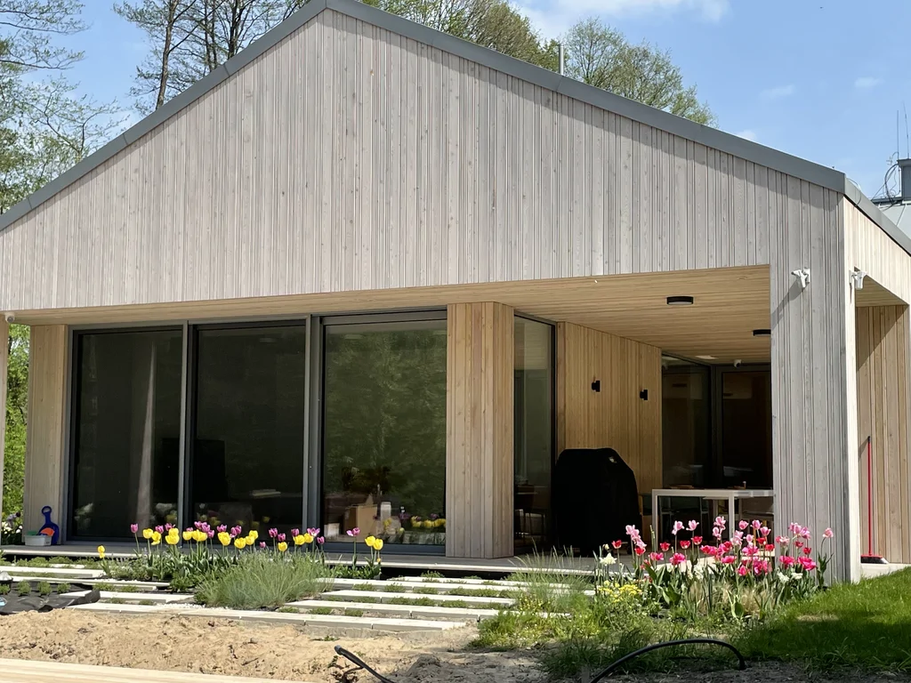 Patio z zadaszeniem i ogrodem przy nowoczesnym domu