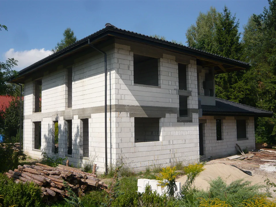 Dom z wykonanym dachem, rynnami i wstępnymi pracami elewacyjnymi – etap wykończeń zewnętrznych