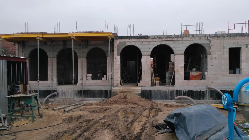 Budowa domu zakonnego, ściany z silikatów na parterze i parterze, na piętrze widoczny szalunek stropu 
