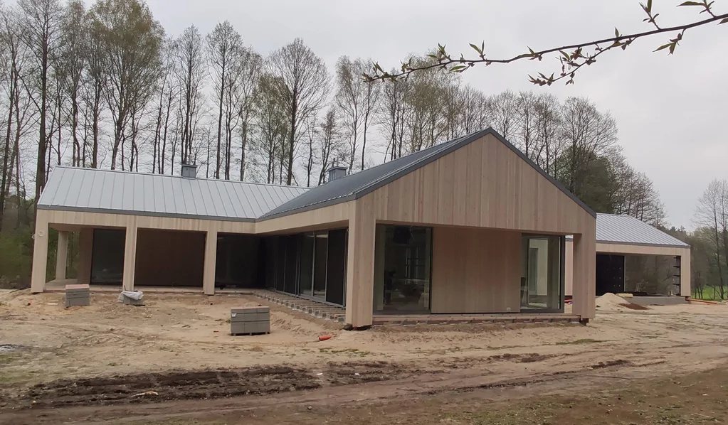 Nowoczesny dom parterowy z podcieniem/tarasem, okładzina drewniana i dach z blachy na rąbek stojący