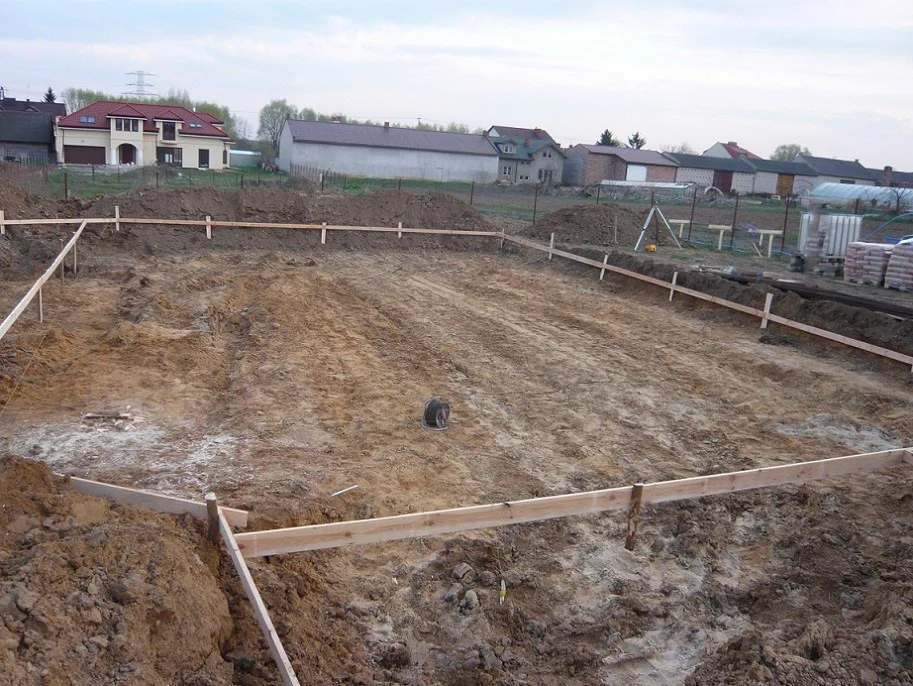 Wyrównany wykop pod budowę domu z wytyczonym obrysem fundamentów