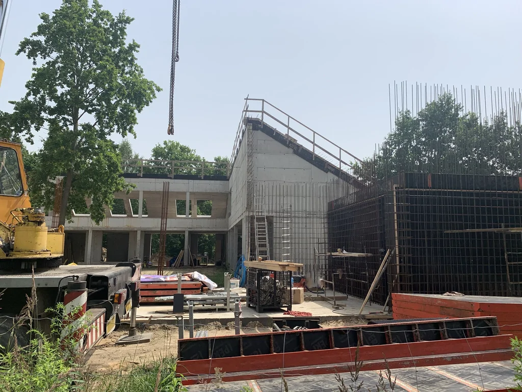 Plac budowy: zbrojenie ścian i elementów żelbetowych – etap realizacji ścian z betonu architektonicznego i stropu skośnego