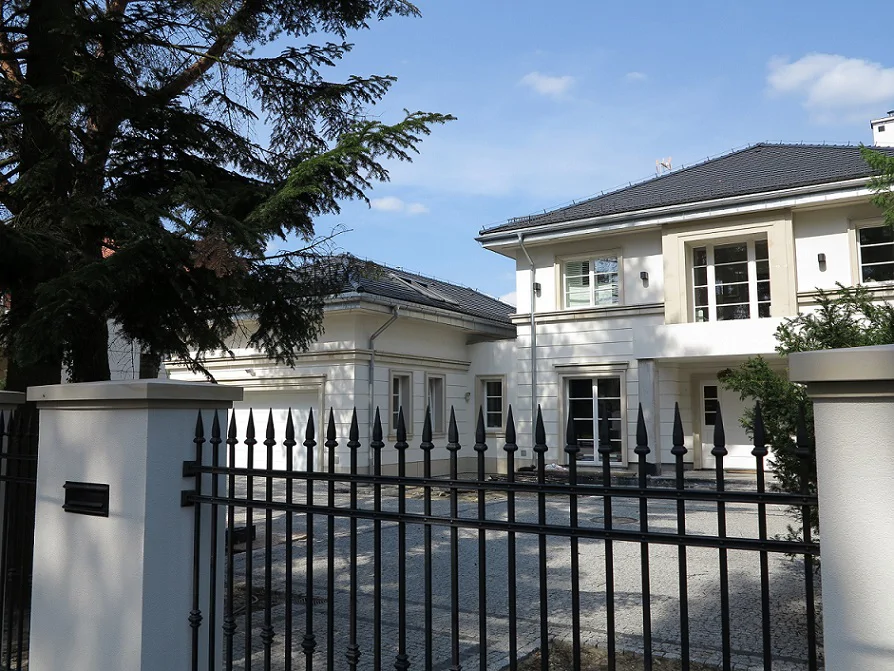 Dom jednorodzinny w stanie deweloperskim, widok od bramy na podjazd i garaż