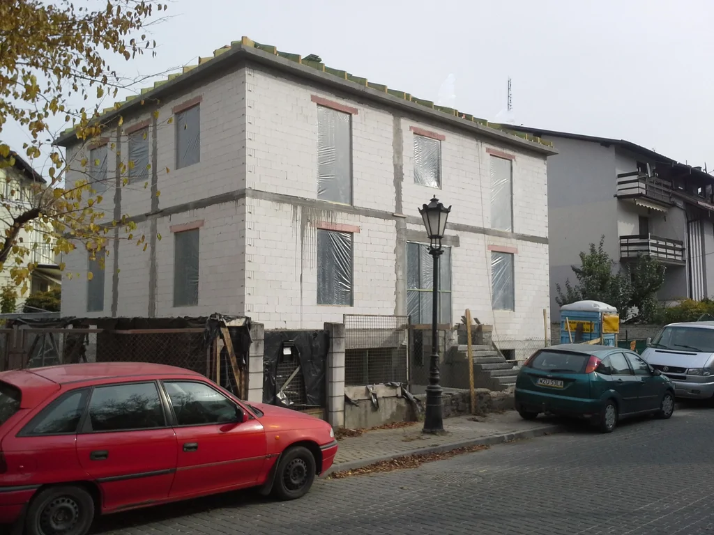 Budowa domu jednorodzinnego widok na gotowy stan surowy, zabezpieczone otwory okienne 