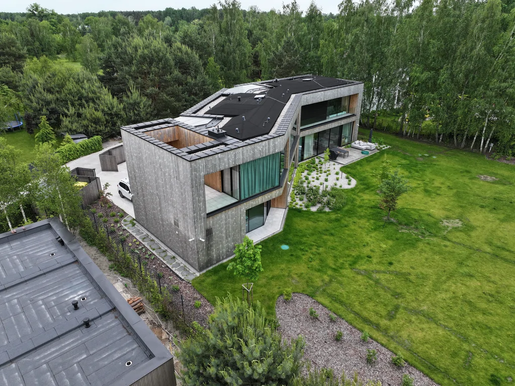 Dom Prawdziwka – narożne ujęcie z drona: duże okna, taras i rozległy ogród przy domu.