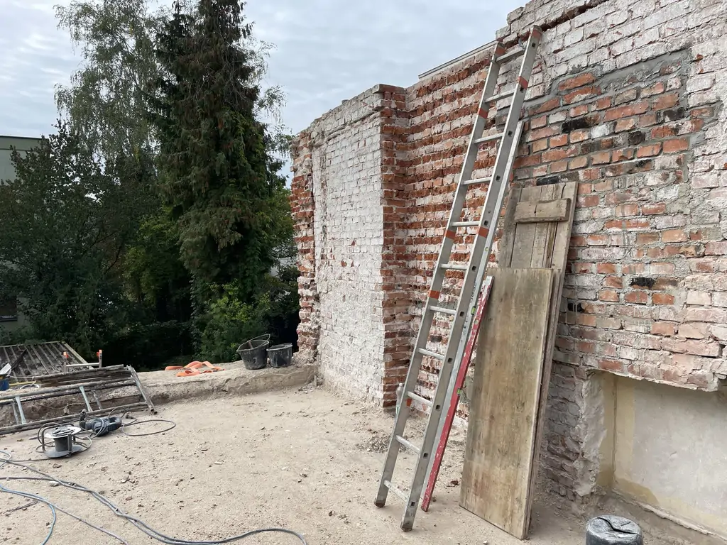 Odsłonięte ceglane ściany podczas prac rozbiórkowych i przygotowania do przebudowy konstrukcyjnej.