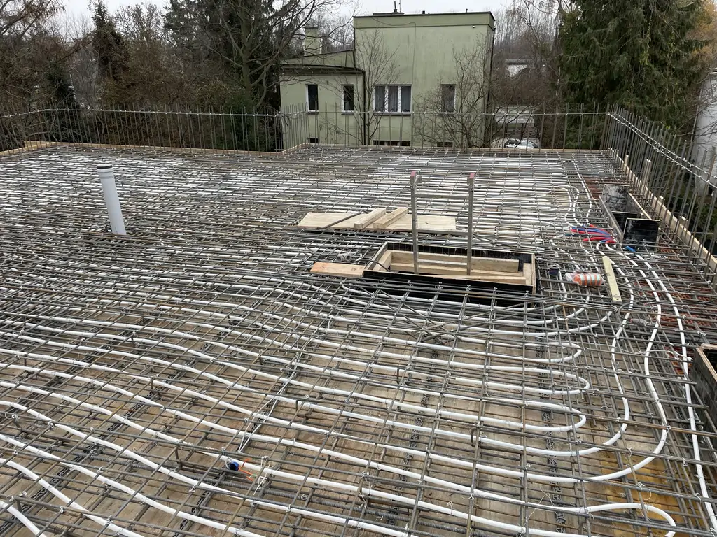 Strop w trakcie prac konstrukcyjnych – zbrojenie płyty i rozprowadzenie instalacji przed betonowaniem.