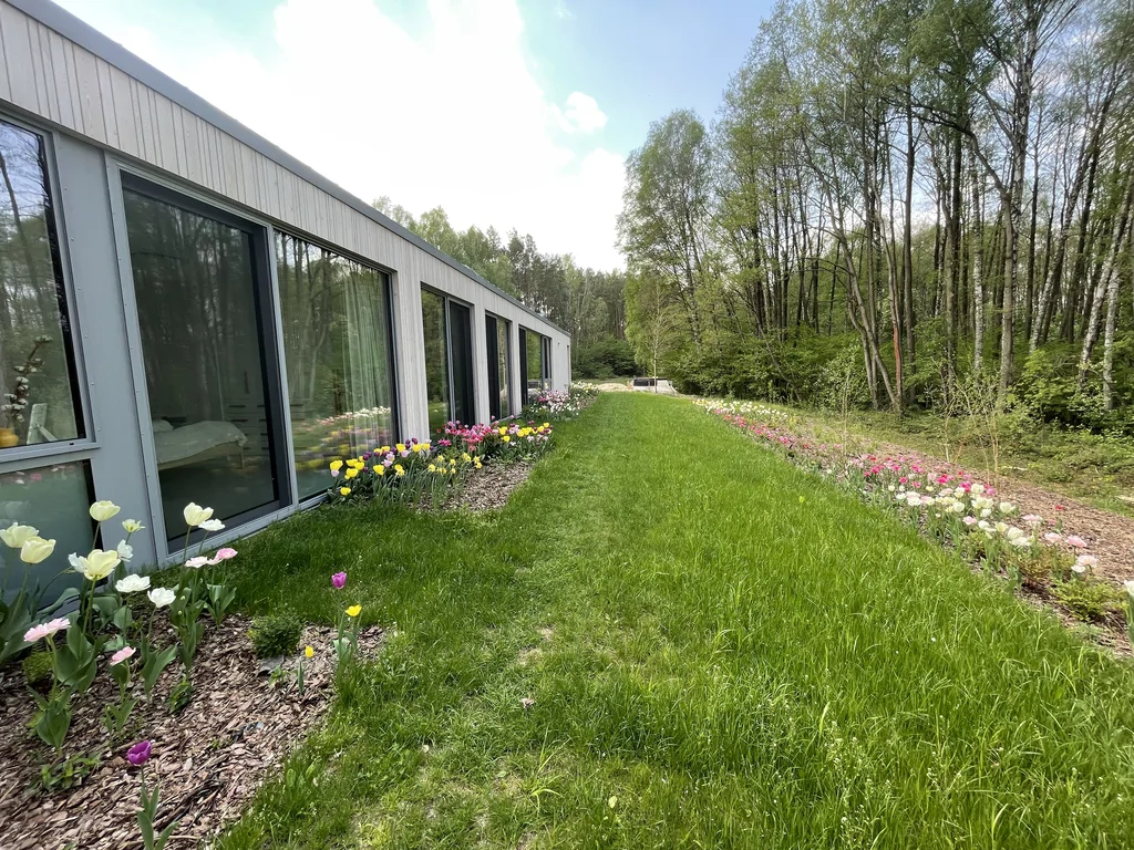 Ogród z rabatami kwiatowymi wzdłuż elewacji domu