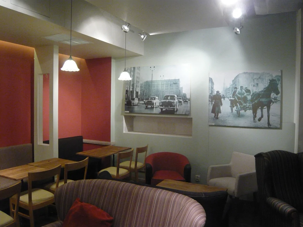 Sala kawiarni Green Caffè Nero po remoncie, stoliki, fotele i dekoracje na ścianach