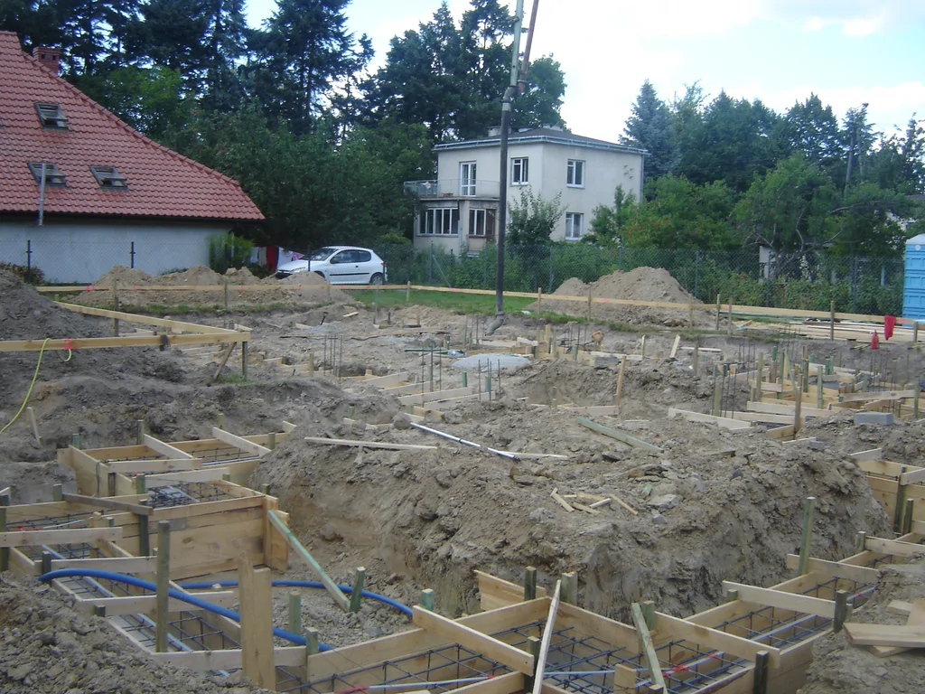 Budowa domu widok na zbrojenie i szalunek ław fundamentowych przed betonowaniem 