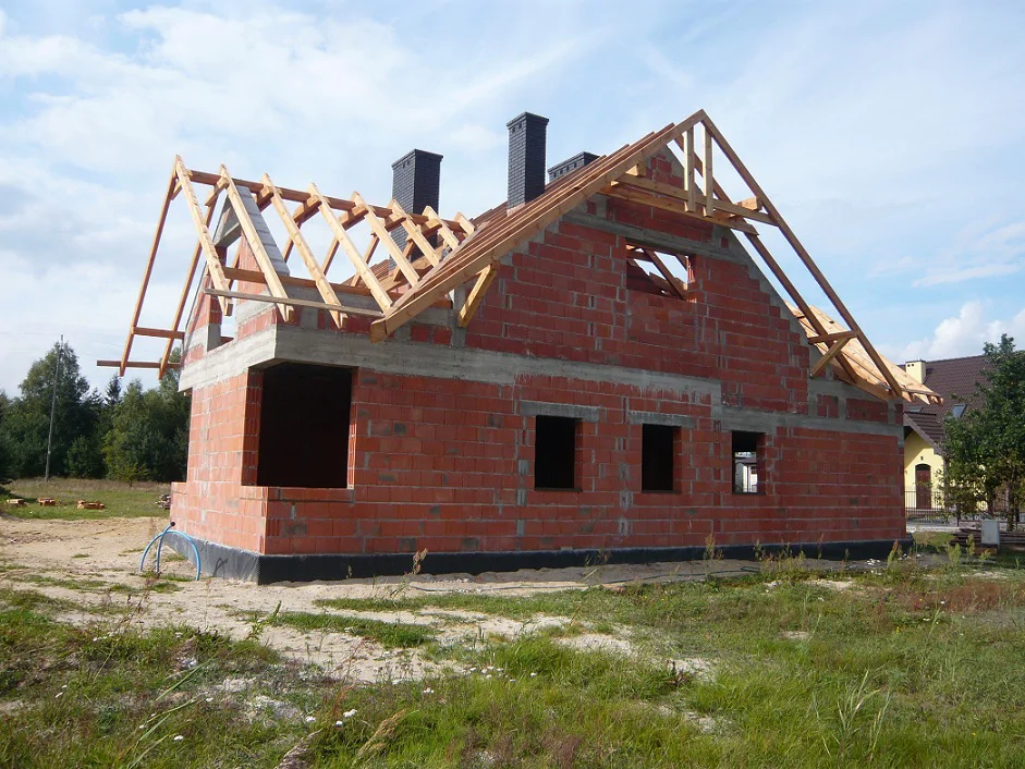 Budynek w stanie surowym z częściowo zmontowaną więźbą dachową, widok z boku
