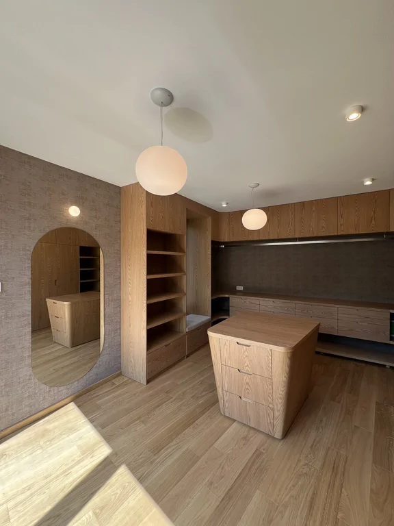 Garderoba na wymiar z wyspą, otwartymi półkami i drewnianą zabudową