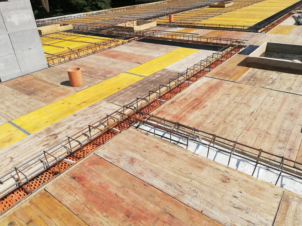 Detal zbrojenia stropu i deskowania dachu płaskiego na budowie domu jednorodzinnego